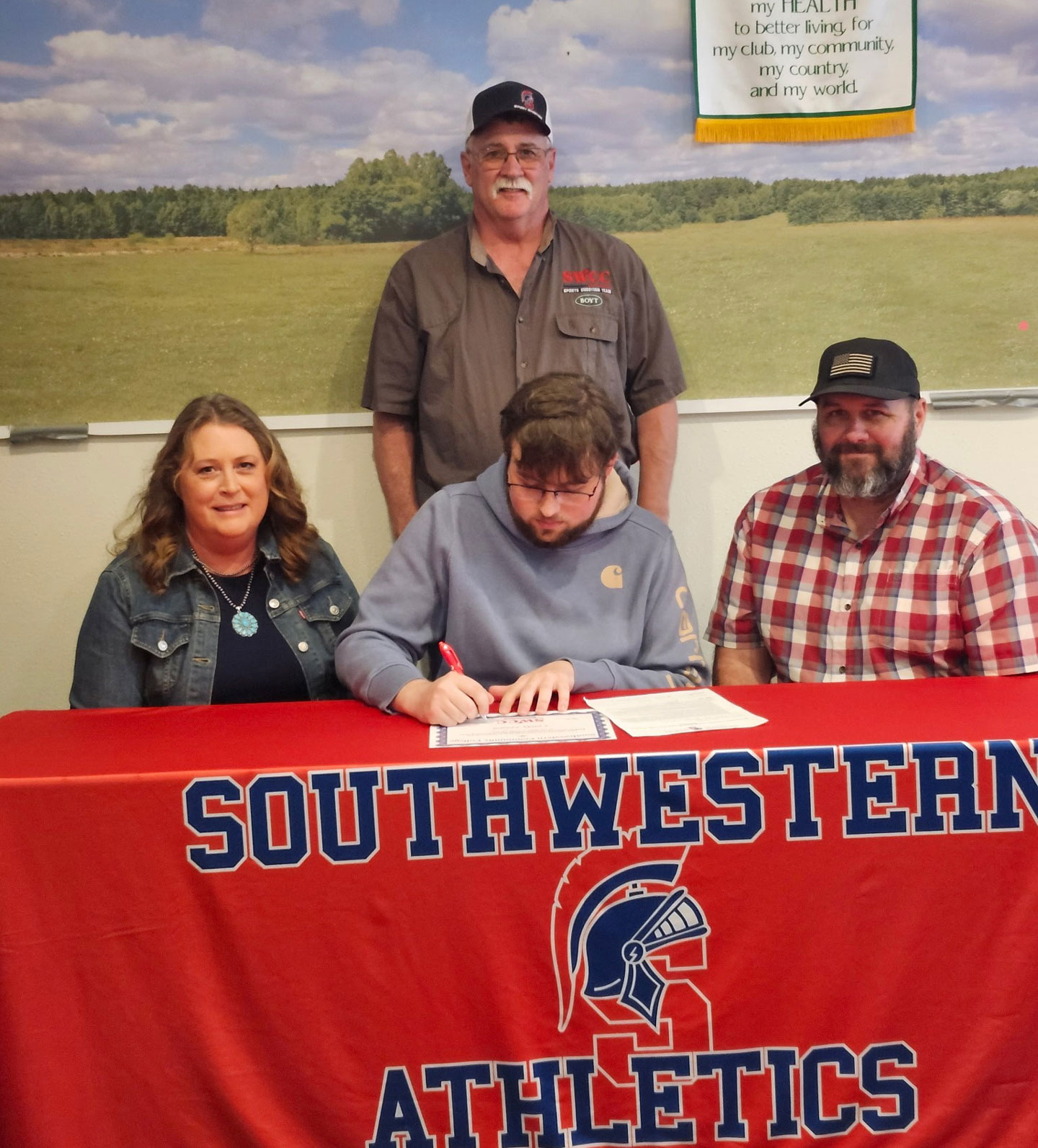 Sitting: Sara, Lundy, and Chad Sanson. Standing: Mark Johnson, Southwestern sports shooting coach